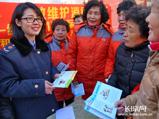 工作人員發(fā)放消費(fèi)者權(quán)益保護(hù)宣傳材料。