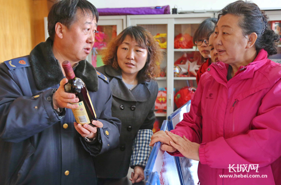 工作人員為天洋新城社區(qū)居民講解紅酒的鑒別方法。