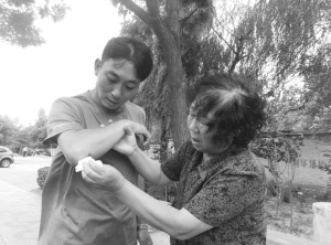 媽媽心疼地為他擦拭傷口