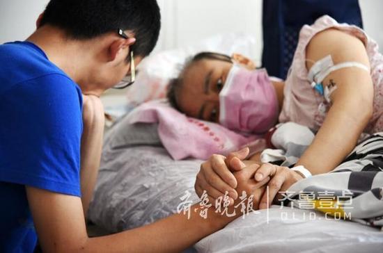 躺在病床上的母親緊緊地牽著兒子的手臂，眼神里有太多的牽掛和不舍。