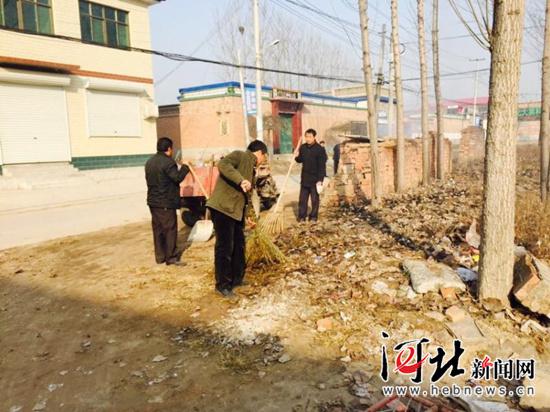 冬天和村民一起清理街道垃圾，右一為梁棟軍