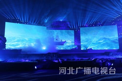 舞蹈《弄潮》。實(shí)體的道具大船揚(yáng)帆在虛擬的驚濤海浪中，營(yíng)造出“弄潮兒向濤頭立，手把紅旗旗不濕”的精神意境。