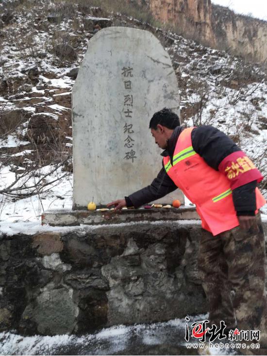 劉海清在烈士墓前擺放貢品。張長江攝